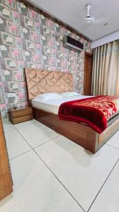 a bedroom with a bed with a red blanket on it at Kamz Homestay Chandigarh 35 in Chandīgarh
