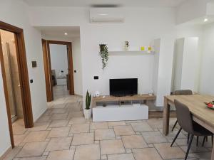 a living room with a table and a television at 10 min Airport & WIFI - Wonderful Villa 5 Stelle in Stazione Bari Centrale