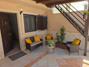 a patio with yellow pillows and chairs and a staircase at 10 min Airport & WIFI - Wonderful Villa 5 Stelle in Stazione Bari Centrale
