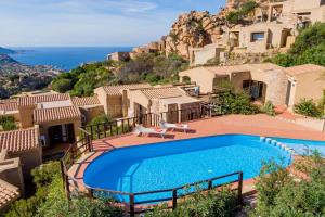 a villa with a swimming pool and a view of the ocean at Violetta Nellie Sardinia Unlimited in Costa Paradiso