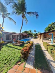 a resort with a swimming pool and palm trees at Pousada Solar das Fontes in Beberibe