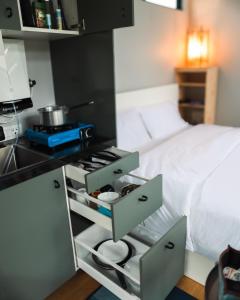 a small kitchen with a stove and a bed at Wind over Waters Cabin 2 in Lavasa +22 photos