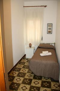 a small bedroom with a bed and a window at Casa Barranco in Cefalù