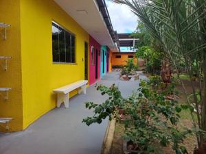 a yellow building with a bench in a courtyard at Pousada do Mel- Iranduba in Iranduba
