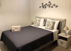 a bedroom with a bed with a black comforter and pillows at KadroVilla II in Nafplio