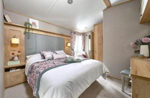 a bedroom with a large white bed in a room at Unity Skirlington Coast Yorkshire in Skipsea +16 photos