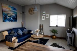 a living room with a blue couch and a table at Noel's Place in Doolin