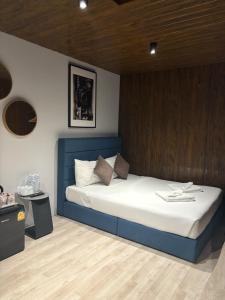 a bed with a blue headboard in a room at Icon Hotel Hatyai in Hat Yai