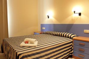 sypialnia z łóżkiem z dwoma ręcznikami w obiekcie Apartaments Tamariu w mieście Tamariu