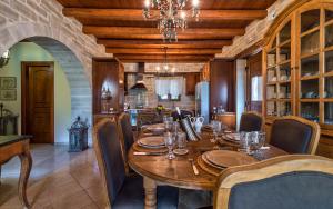 a dining room with a wooden table and a kitchen at Eleon Residence in Stavromenos