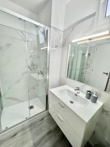 a white bathroom with a sink and a shower at Brisas de Sardina Apartment in Sardina +26 photos