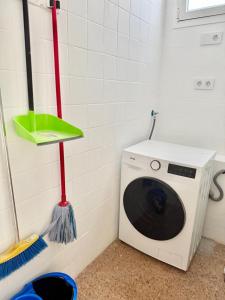 a washing machine in a room with a broom at Brisas de Sardina Apartment in Sardina