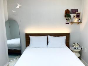 a bedroom with a bed with white pillows at Moeul Stay in Gyodong in Daegu