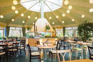 a restaurant with tables and chairs and a large ceiling at Hotel Am Terrassenufer, WorldHotels Distinctive in Dresden