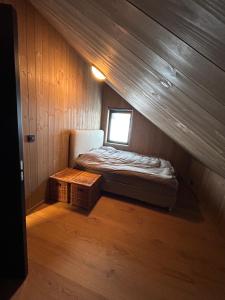 une petite chambre mansardée avec un lit et une fenêtre dans l'établissement Soleiknuten Ålsheia Moderne Hytte i Naturskjønne Omgivelser, à Tjørhom
