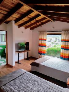 a bedroom with two beds and a large window at House life- La Calera in La Calera