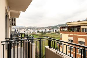 an apartment balcony with a view of a city at Tirent Apartment-Modern Bedrooms Stay Near Liqeni i Thatë in Tirana