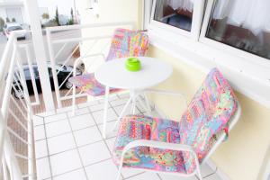 a white table and two chairs and a white table and two windows at Ferienwohnung Spatzennest in Kronau