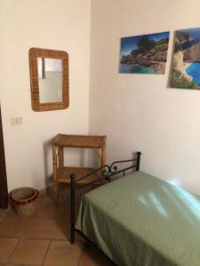 a bedroom with a bed and a mirror and a table at Baglio Marotta in Valderice