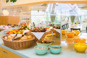 una mesa con cestas de frutas y otros alimentos en Hotel Am Terrassenufer en Dresden