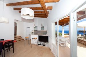 Una cocina y una sala de estar con mesa y sillas. en Ficula Vell Beachfront Villa with Private Pool, en Punta Grossa