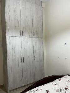 a bedroom with white cabinets and a bed at Kantouni house Chios in Pyrgi