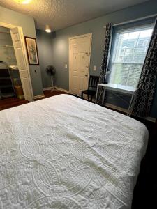 a bedroom with a bed with a white comforter at Vet School - Pools Full Kitchen Queen Bed in Auburn