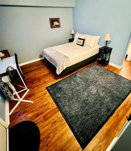 a bedroom with a bed and a black rug at Vet School - Pools Full Kitchen Queen Bed in Auburn