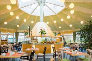 a restaurant with tables and chairs and a large ceiling at Hotel Am Terrassenufer in Dresden