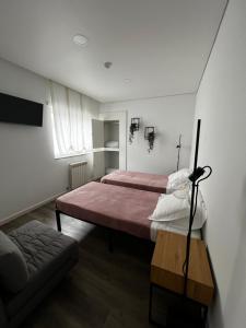 a bedroom with two beds and a couch at The Spot Ofir in Esposende