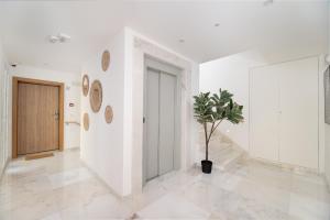 a hallway with a door and a potted plant at Safira Suites 101 in Funchal