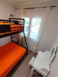 a bedroom with a bunk bed and a chair and a window at EAR - house Karia Lefkada in Kariá