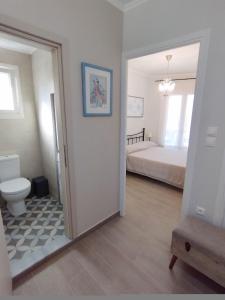a bathroom with a toilet and a bedroom with a bed at EAR - house Karia Lefkada in Kariá +16 photos