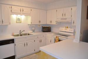 una cucina bianca con mobili bianchi e un lavello di 5 Vaqueria Lane a Hot Springs Village