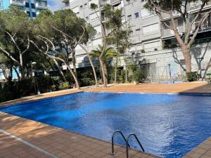 a large blue swimming pool in front of a building at Apartamento playa in Blanes