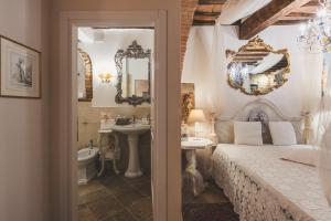 a bedroom with a bed and a sink and a mirror at La Romantica Lolo' in Montepulciano