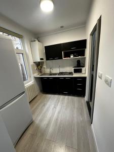 a kitchen with a sink and a refrigerator at Garsoniera lângă Palatul Parlamentului in Bucharest