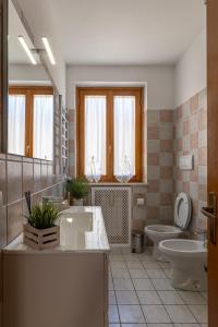 a bathroom with two sinks and a toilet and a mirror at Il Cammino in San Quirico dʼOrcia +38 photos