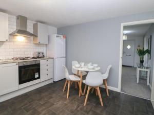 a kitchen with a table and chairs in a kitchen at Cheshire House in Castleton +24 photos
