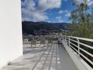 einen Balkon mit Stühlen und Bergblick in der Unterkunft Pico Barcelos - Funchal in Funchal