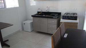 a small kitchen with a sink and a stove at KITNET PROX AO CENTRO - AR COND, WI-FI e ESTACIONAMENTO GRATIS in Maringá +50 photos