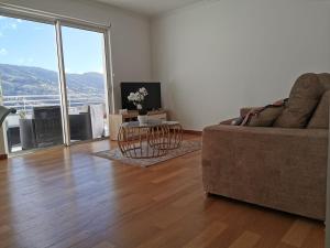 ein Wohnzimmer mit Sofa und Tisch in der Unterkunft Pico Barcelos - Funchal in Funchal