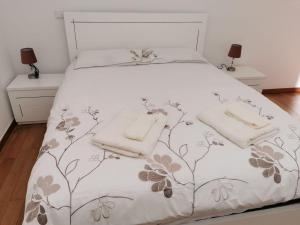 ein Schlafzimmer mit einem weißen Bett mit Handtüchern darauf in der Unterkunft Pico Barcelos - Funchal in Funchal