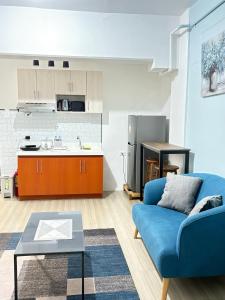 a living room with a blue couch and a kitchen at Cozy stay Cebu in Lapu Lapu City