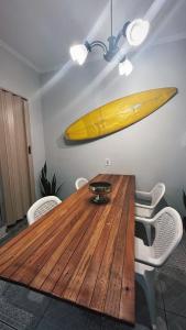 a wooden table with a surfboard hanging on the wall at Chalé Privativo Surfers Itaguá in Ubatuba