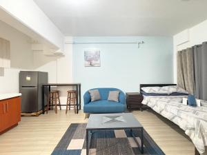 a living room with a blue chair and a couch at Cozy stay Cebu in Lapu Lapu City +41 photos