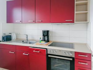 a kitchen with red cabinets and a sink at Ferienhaus "Steffi" in Rerik +28 photos