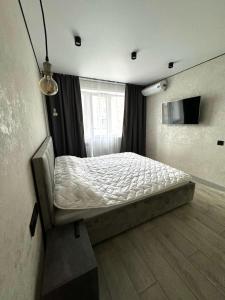 una camera da letto con un letto e una finestra di 1 комнатная квартира город Экибастуз a Ekibastuz