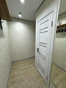 un armadio con porta bianca e pavimento in legno di 1 комнатная квартира город Экибастуз a Ekibastuz