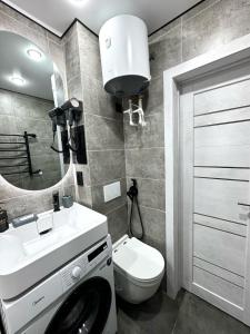 un bagno con lavandino, WC e specchio di 1 комнатная квартира город Экибастуз a Ekibastuz